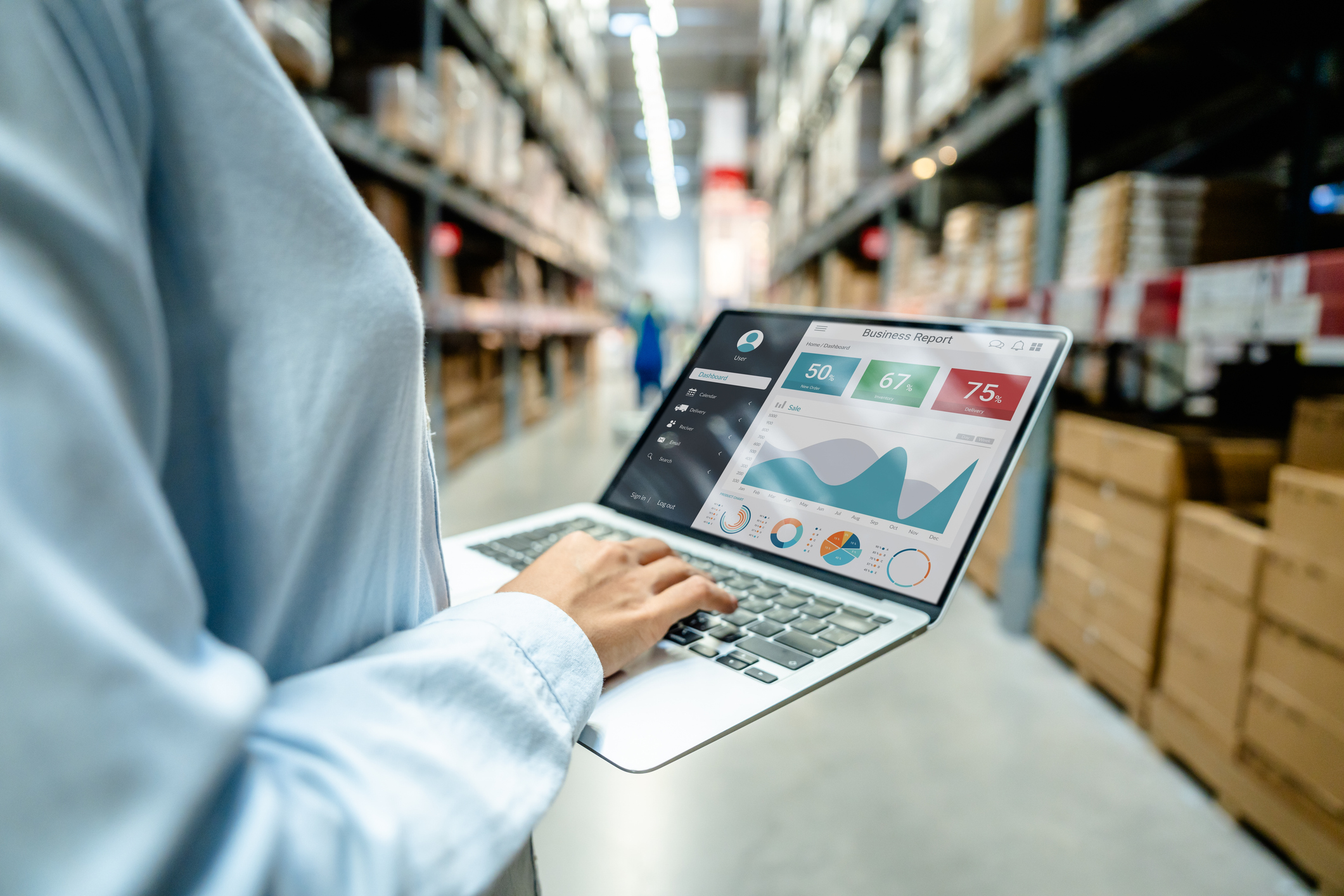 Warehouse manager reviewing analytics dashboard on laptop in a storage facility